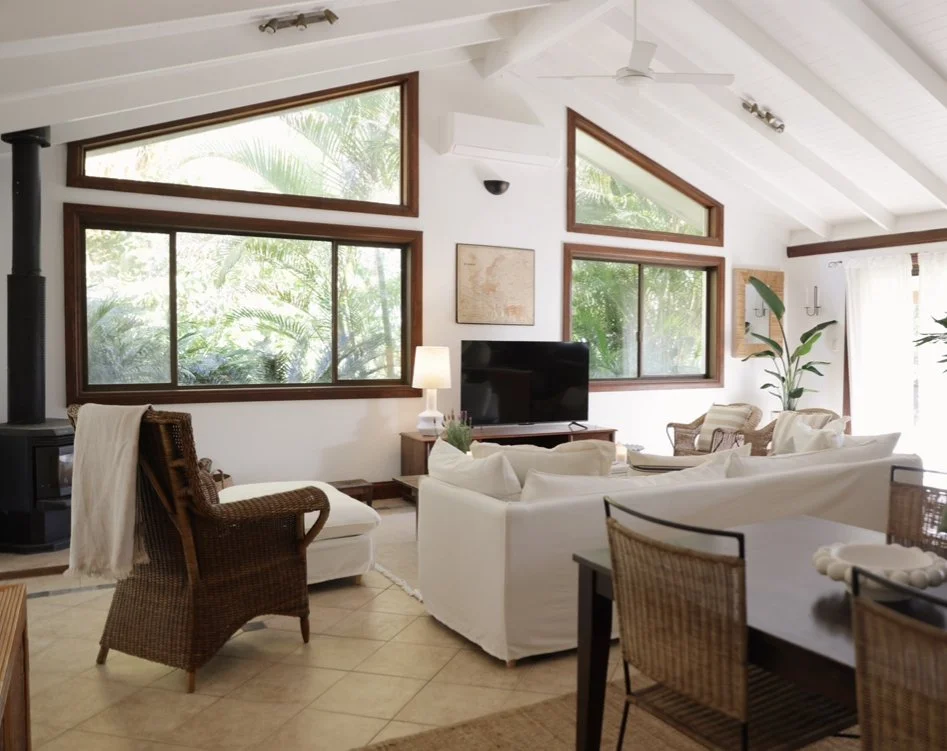 Bangalow home living room after transformation — white sofas, rattan, bright and open