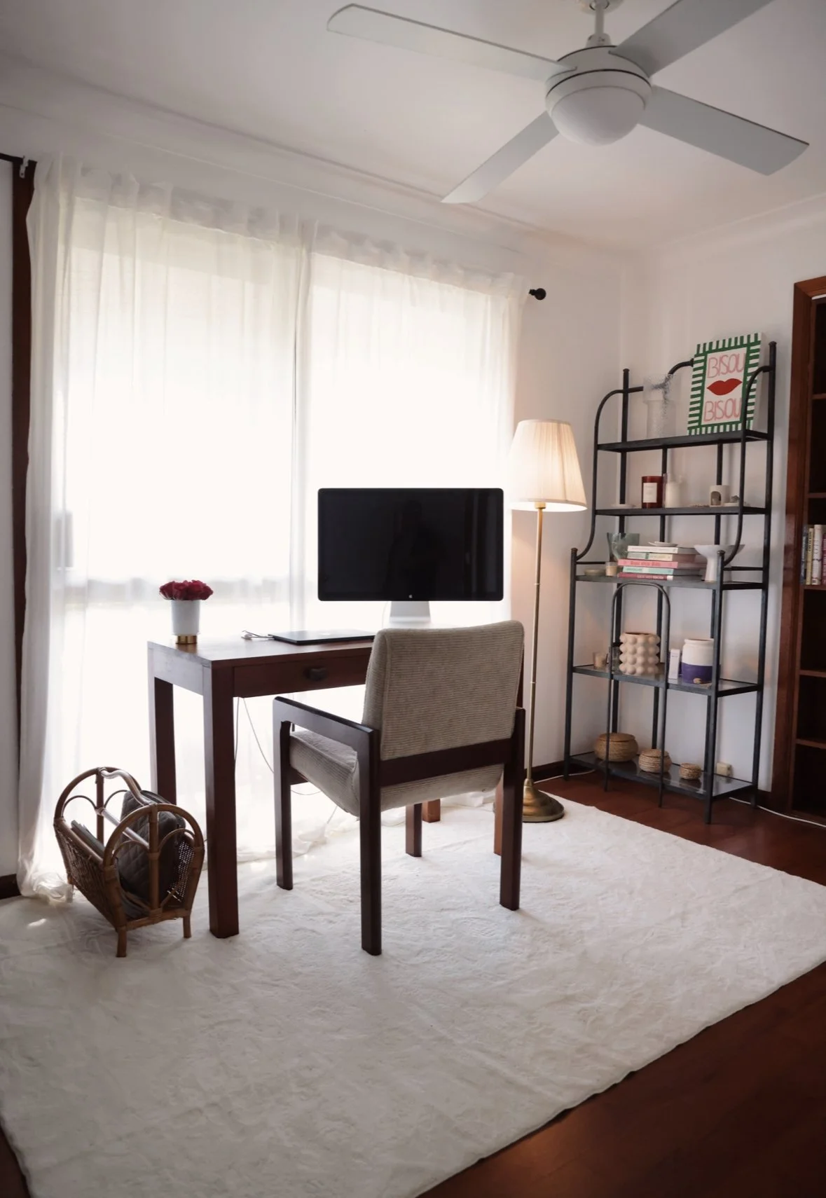 Home office after — clean desk, curated shelving, sheer curtains, calm and light-filled
